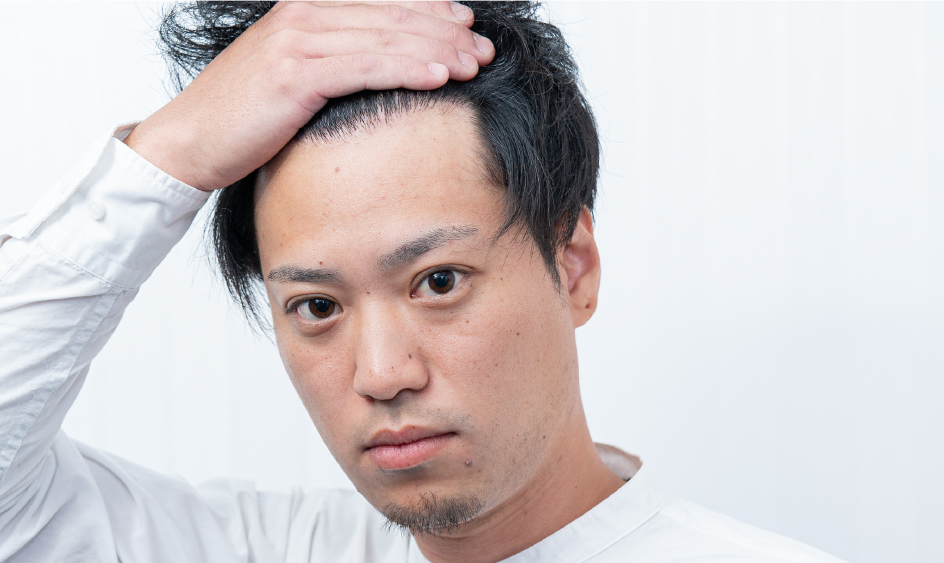 髪の状態を確認する男性